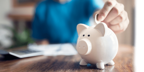 hand putting coin into piggy bank