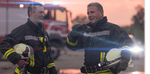 Two fireman talking on a walkie talkie
